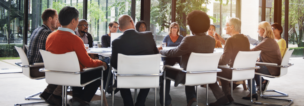 Group of employees sitting together to represent the post titled Understanding and Achieving Regulatory Compliance: A Guide