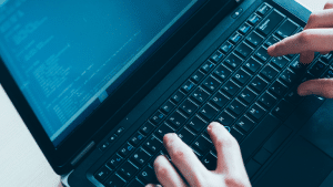 Person typing on a laptop to represent the post incorporating test data and data compliance in devops