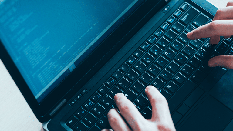 Person typing on a laptop to represent the post incorporating test data and data compliance in devops
